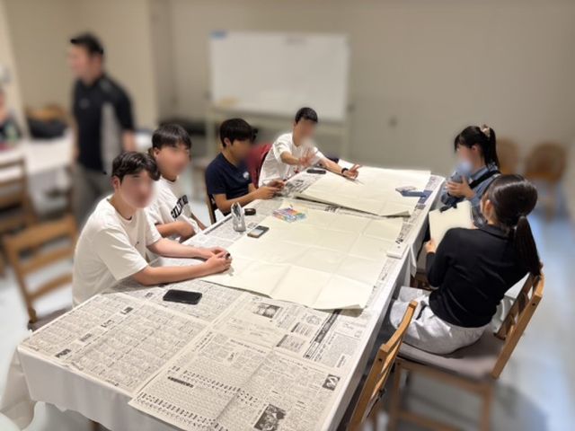 夜のミーティングで発表準備をする様子
